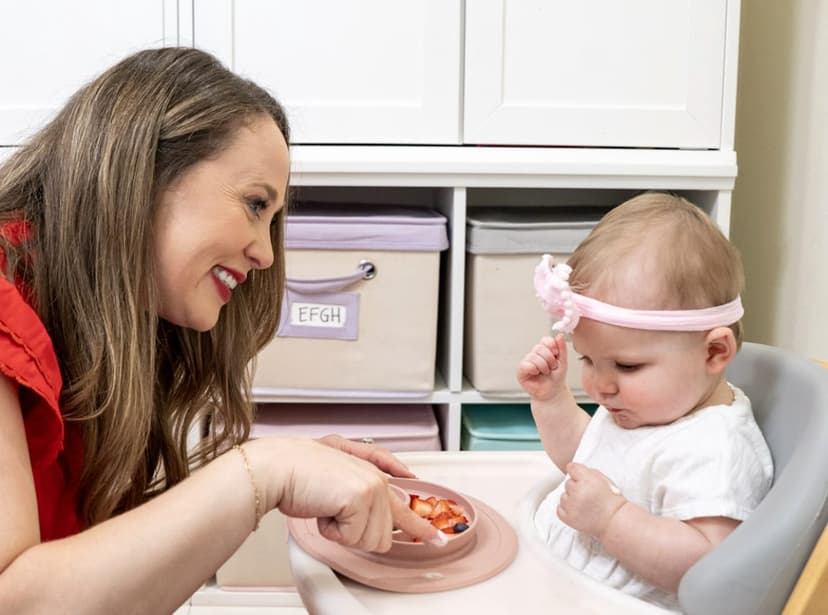 Laura Friedman feeding an infant in a highchair — strawberries on a suction plate during a feeding therapy session